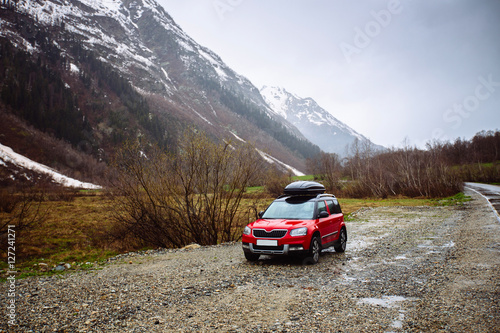 A car with a roof rack on a background of mountains © dron285