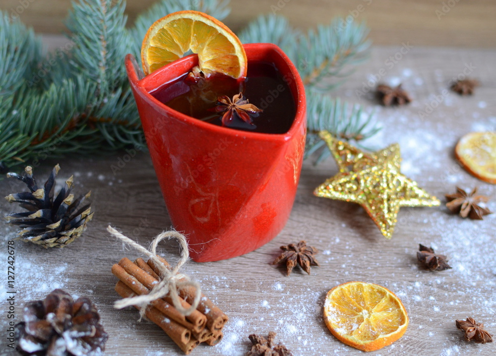 Cup of hot wine with christmas decorations on wooden table Cup of hot wine with christmas decorations on wooden table
