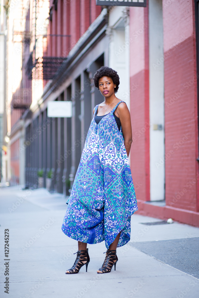 Portrait of young fashionable black woman on city street