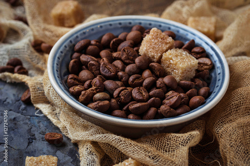 Фотография Bowl of coffee beans and brown cane sugar