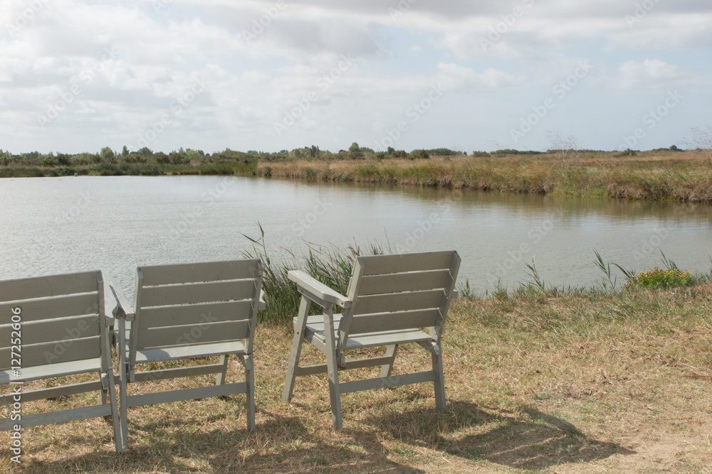 Three wooden chair on relaxing lake at summer Three wooden chair on relaxing lake at summer