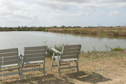 Three wooden chair on relaxing lake at summer
