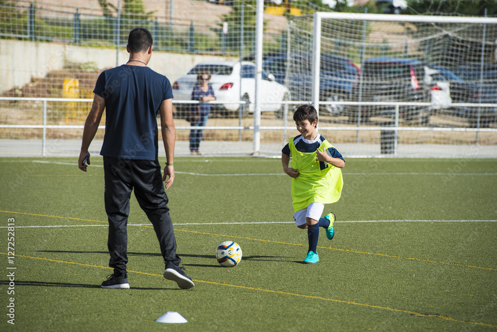 Naklejka premium Niño en un entrenamiento de fútbol 7, deportes de equipo para actividades extraescolares