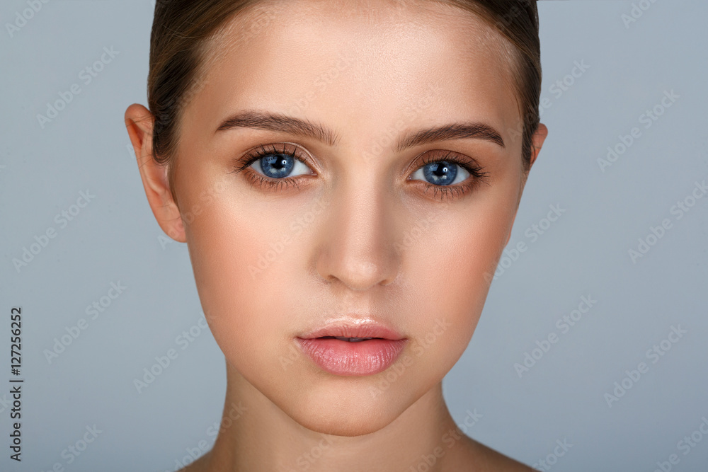 Fototapeta premium Close-up portrait of sexy young woman with beautiful blue eyes. Woman beauty face portrait with healthy skin. Portrait of beautiful young woman looking at camera. Natural beauty concept