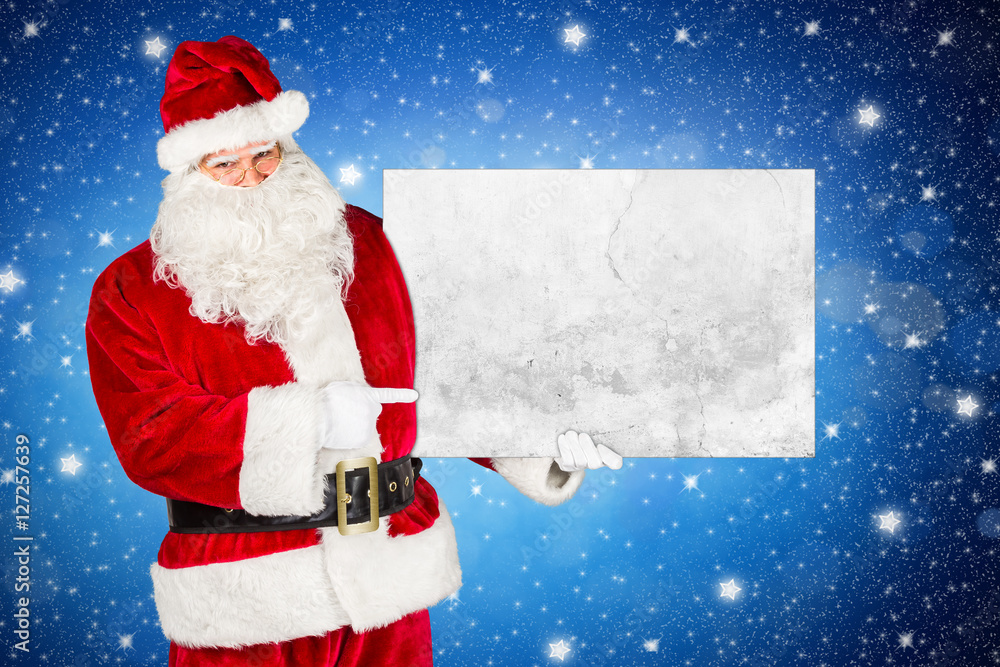 Santa claus holding empty concrete billboard and pointing with his finger in front of blue night sky shiny stars background / weihnachtsmann nikolaus mit leerer Werbetafel vor sternenhimmel blau Santa claus holding empty concrete billboard and pointing with his finger in front of blue night sky shiny stars background / weihnachtsmann nikolaus mit leerer Werbetafel vor sternenhimmel blau