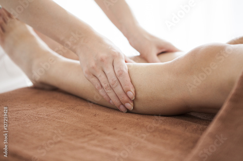The woman is undergoing leg massage at the salon