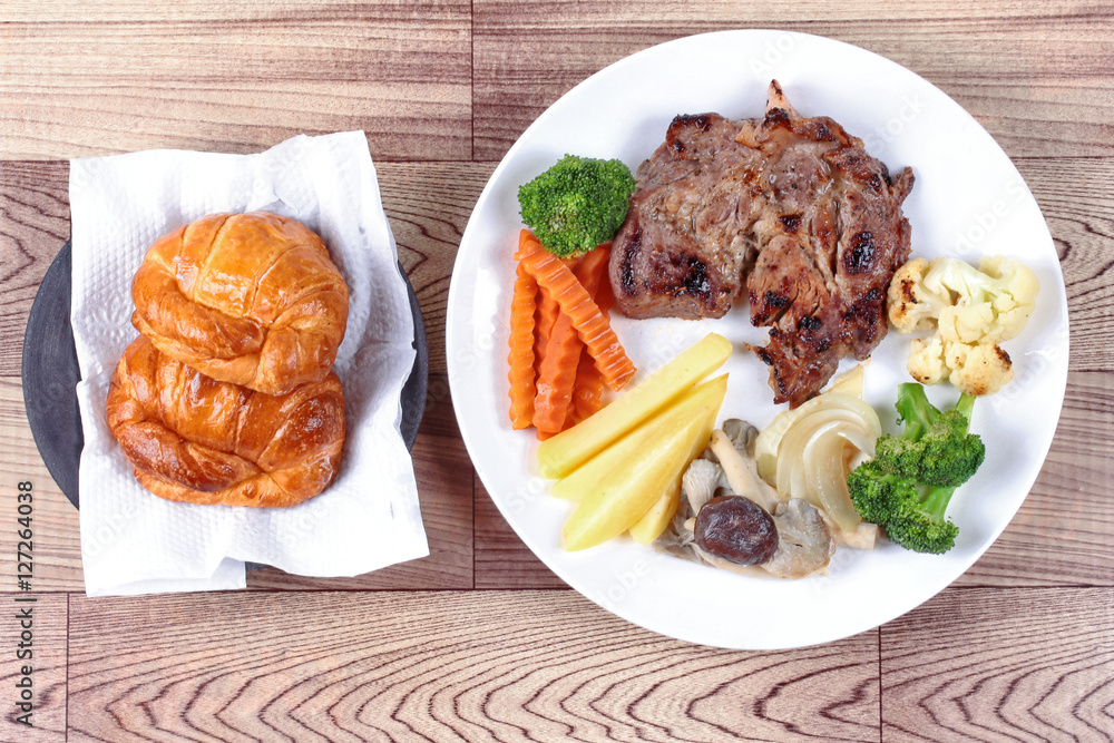 Home made ,Pork steak and mixed vegetables with croissants . Home made ,Pork steak and mixed vegetables with croissants .