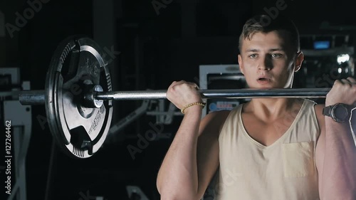 Side view of athlete doing Barbell Curl photo