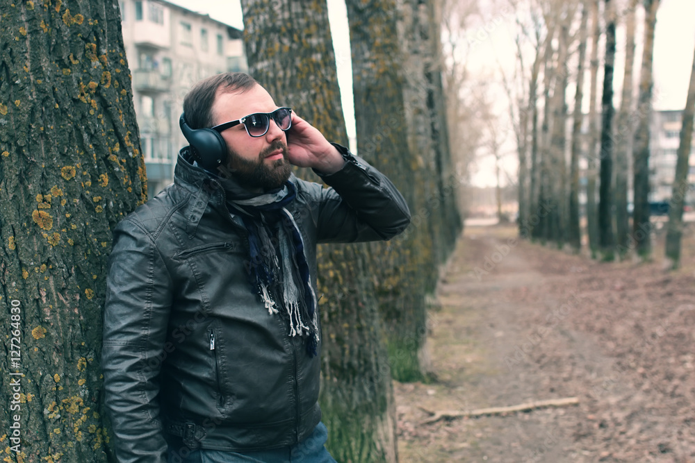 beard man in park with headphon beard man in park with headphon