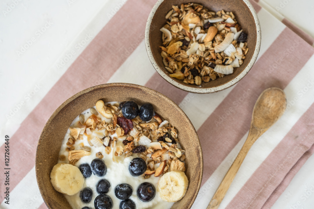 brunch : home made yogurt with granola and banana in wooden bowl. brunch : home made yogurt with granola and banana in wooden bowl.