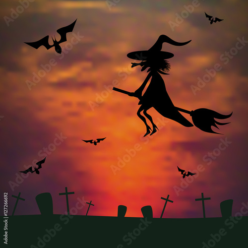 witch flying on a broom against the sunset over the cemetery. ha