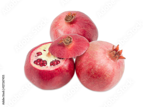 Two whole pomegranates and one cut pomegranate on light background photo