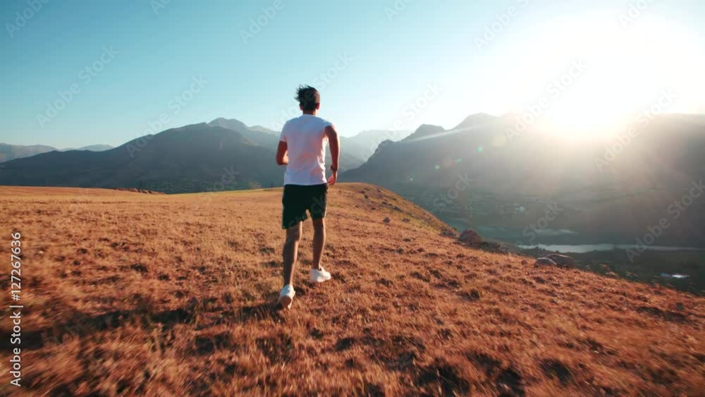 young Indian guy doing a morning jog through mountainous terrain, slow motion, young Indian guy doing a morning jog through mountainous terrain, slow motion,