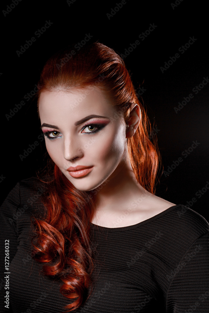 sexy redhead girl in black dress on a black background. beauty