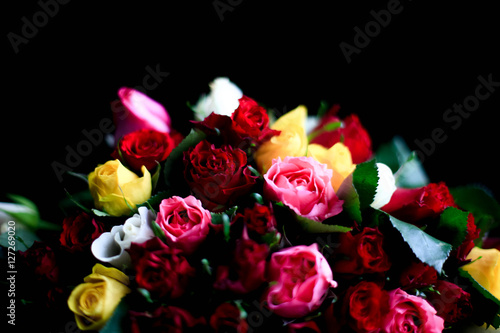 Bouquet of different colorful roses on black background