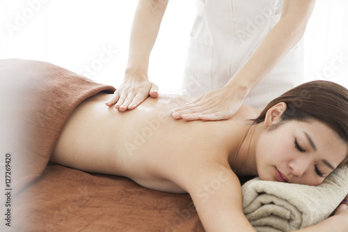 A beautiful Asian woman is undergoing a back massage