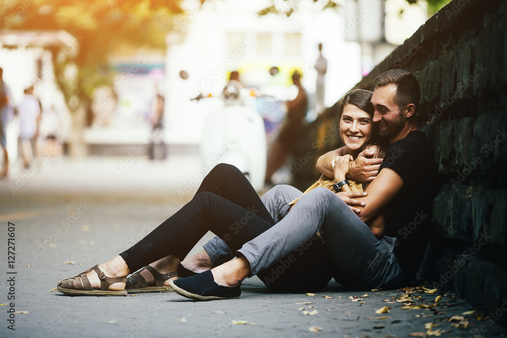 young beautiful couple sitting on the ground