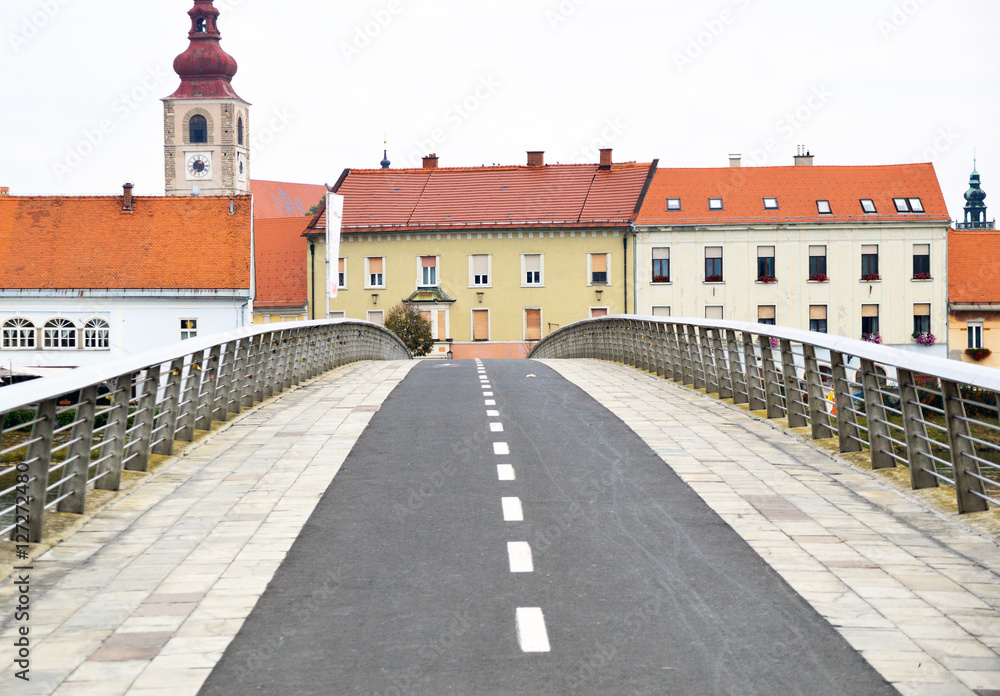 An empty pedestrian and cyclers bridge. View from new to the old part of the town.