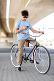 man with smartphone and earphones on bicycle