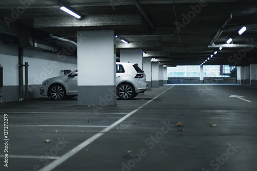 White car parked in empty parking garage.