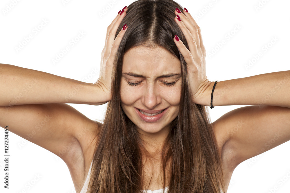 happy young woman is holding her hands to the head