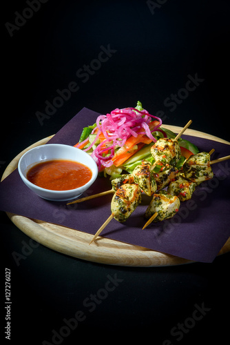 Chicken on skewers with salad