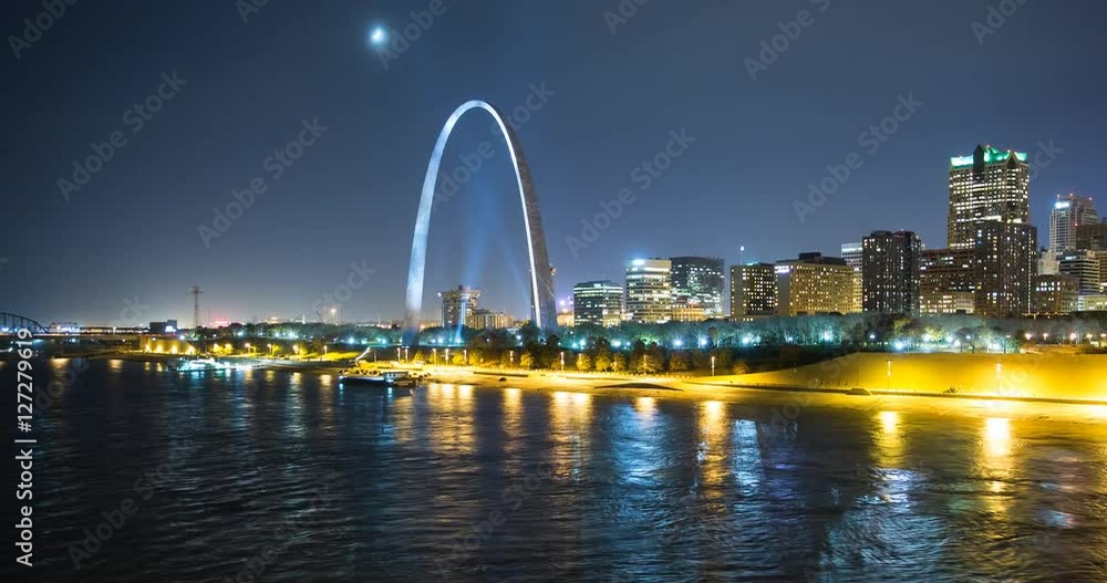 St. Louis, Missouri, USA - view of the illuminated city at night with the Gateway Arch monument and the Mississippi River with passing ship - Timelapse with pan right to left St. Louis, Missouri, USA - view of the illuminated city at night with the Gateway Arch monument and the Mississippi River with passing ship - Timelapse with pan right to left