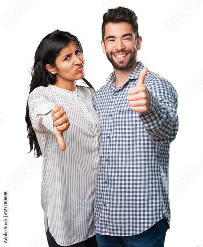 young couple doing a contradictory symbol photo