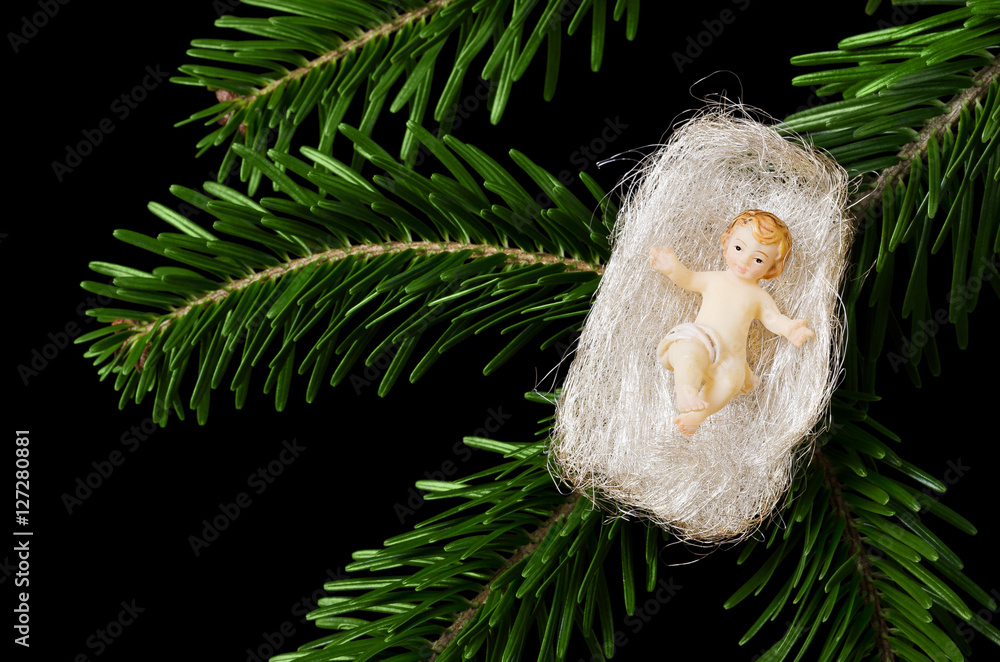 Christ child figurine in angel hair on a fir branch on black ...