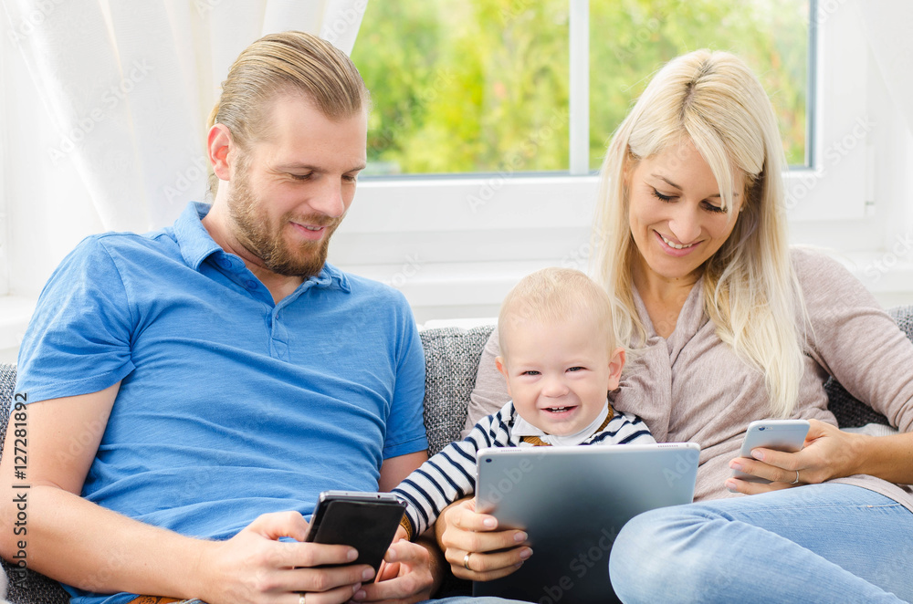 Junge Familie mit Tablett und Handy Junge Familie mit Tablett und Handy