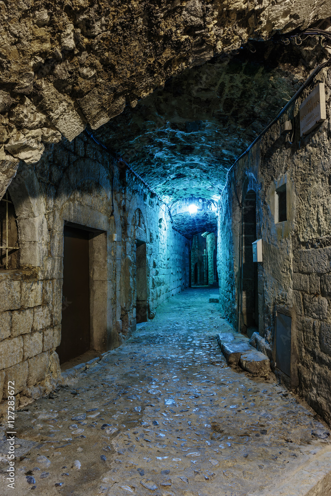Narrow cobbled street in old town Peille at night, France.