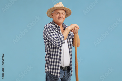 Mature farmer posing on blue background photo