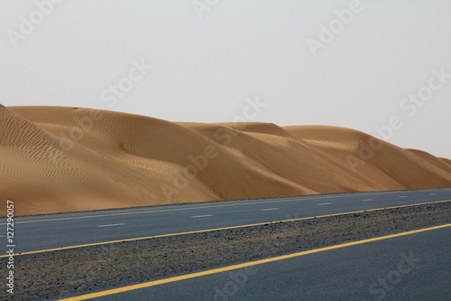 An empty road next to a desert in Dubai