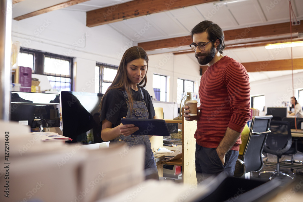 Two Designers Using Digital Tablet In Busy Office Two Designers Using Digital Tablet In Busy Office