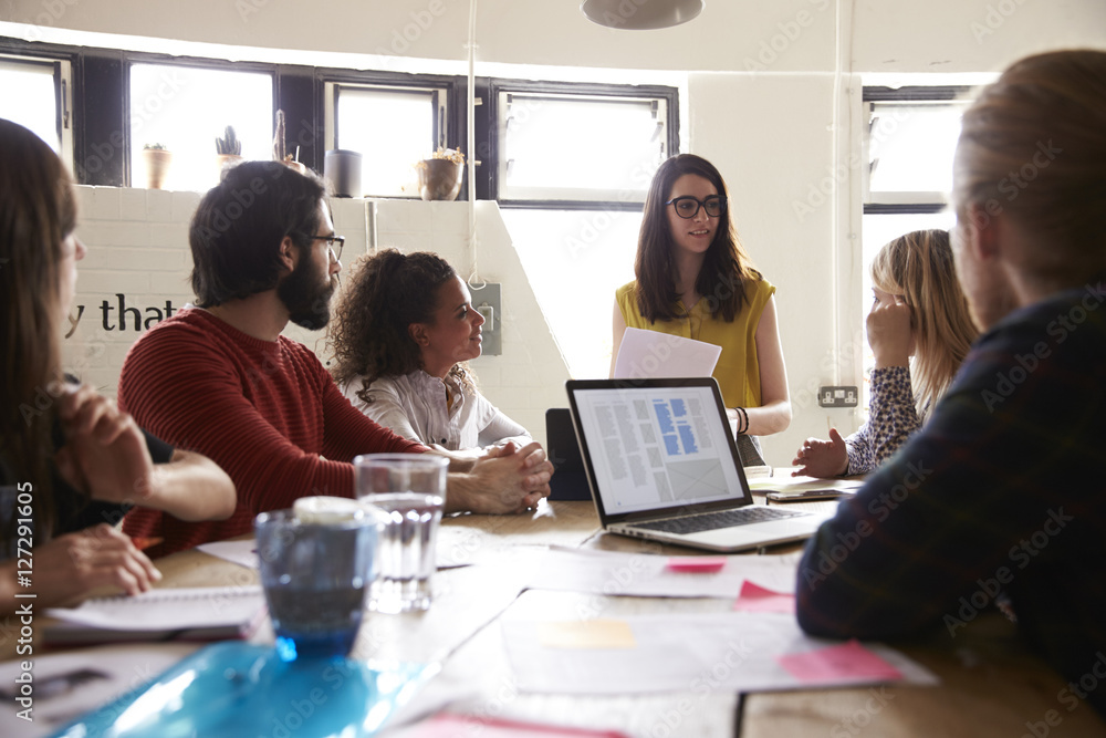 Female Manager Leads Meeting Around Table In Design Office Female Manager Leads Meeting Around Table In Design Office