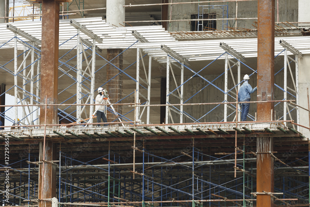 worker making level on steel column