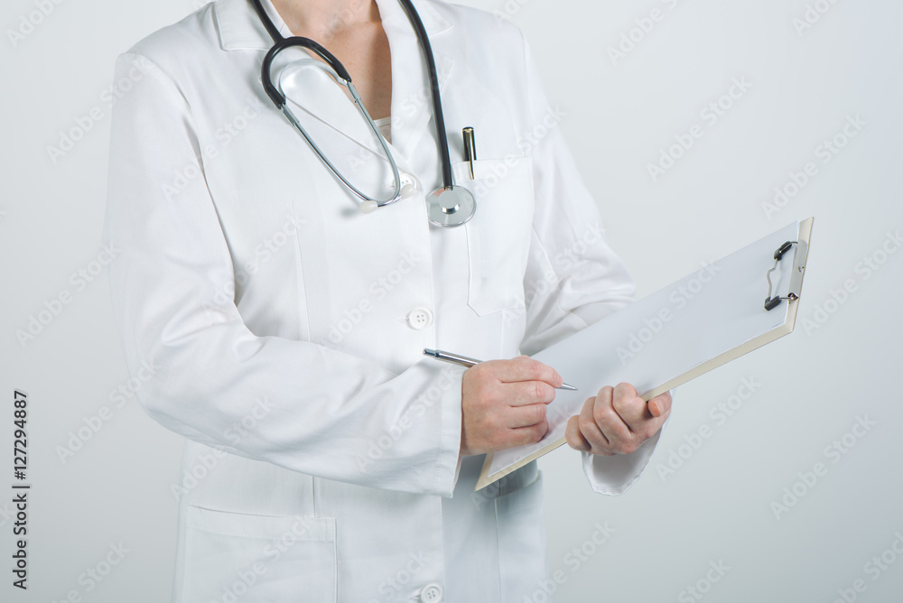 Female doctor writing on clipboard notepad blank paper Female doctor writing on clipboard notepad blank paper