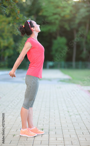 View Of Sporty Young Woman Doing Morning Exercise In Park