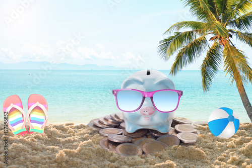 travel piggy bank with sunglasses relax on the beach holiday. concept saving money for travel in holiday © NaMong Productions