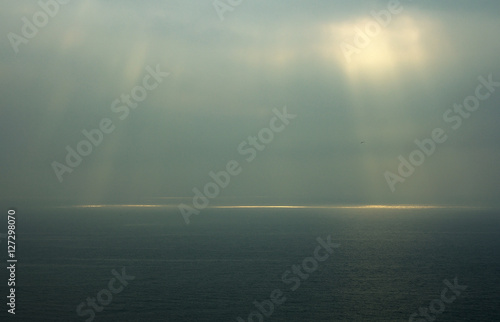 Fotografie Sea horizon with ripples against grey sky at dusk bleakness over seascape backg