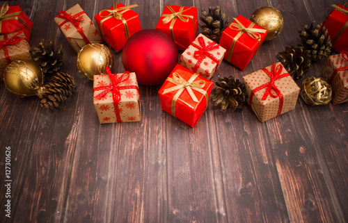 Christmas or New Year background: gifts, colored glass balls, decoration and cones on wooden background 