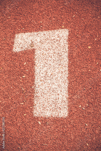 Numbers one on rubber running track standard red color.