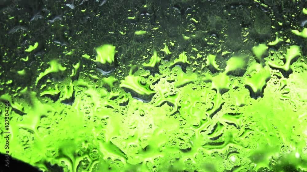 Waterdrops on the glass and defocused green apples against black background 4K shot Waterdrops on the glass and defocused green apples against black background 4K shot