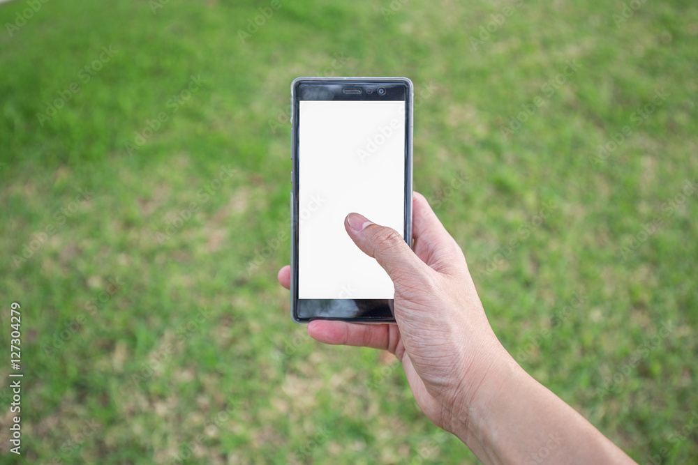 Right hand holds mobile phone in park