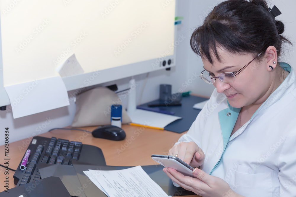 Female x-ray doctor surfing the internet with her smartphome. Selective focus Female x-ray doctor surfing the internet with her smartphome. Selective focus