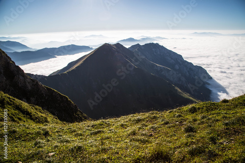 mystische Wolken und Nebelschleier zwischen Berggipfeln im Spätsommer in den Alpen photo