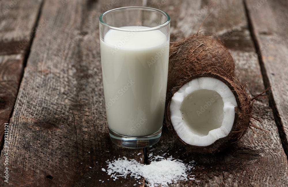 Vegetarian breakfast. Macro shot of coconut and milk on wooden table. Vegetarian breakfast. Macro shot of coconut and milk on wooden table.