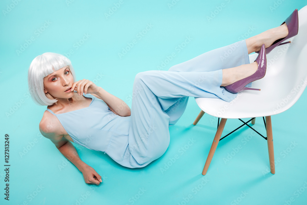 Gorgeous young woman lying and posing with legs on chair Gorgeous young woman lying and posing with legs on chair