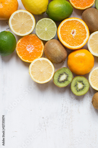 Fototapeta Naklejka Na Ścianę i Meble -  Fruits reach in vitamin C: oranges, lemons, limes, clementines, kiwis, top view, copy space for text, selective focus