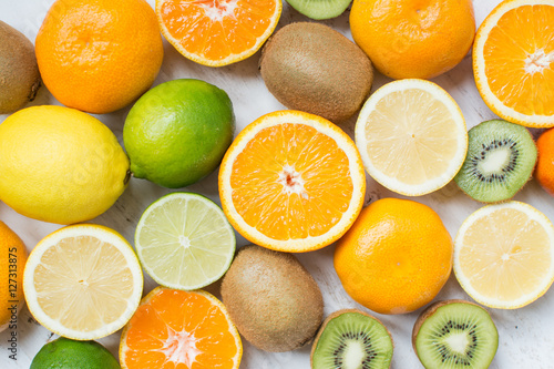 Fruits rich in vitamin C: oranges, lemons, limes, clementines, kiwis, top view, selective focus photo